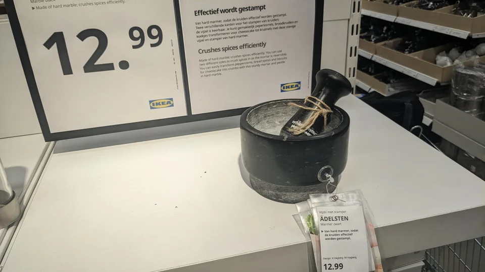 Black IKEA ÄDELSTEN mortar and pestle with its product label in a Delft store display