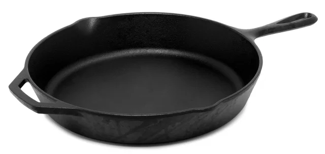 Empty dark skillet with a long handle and helper handle on a white background