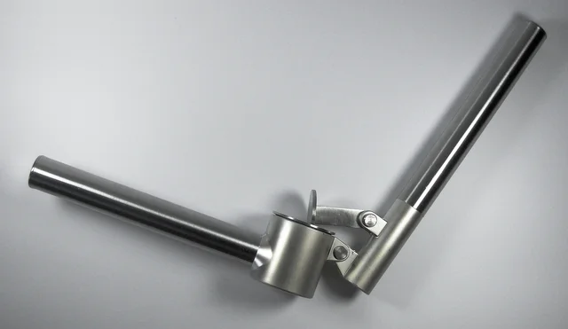 Open metal garlic press showing its two handles and pressing chamber
