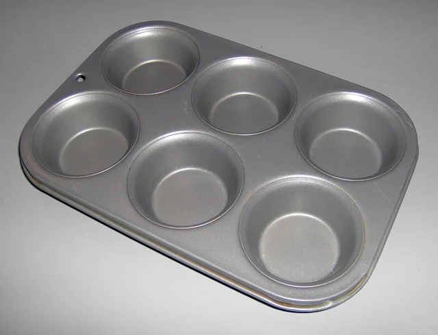 Grey muffin tray with six circular cavities arranged in two rows