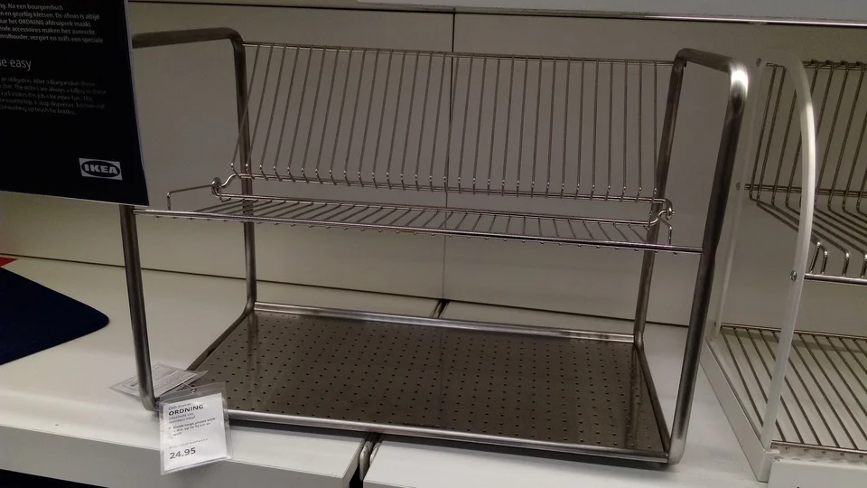 IKEA ORDNING dish drainer with an upper plate rack and perforated lower tray, displayed in Delft
